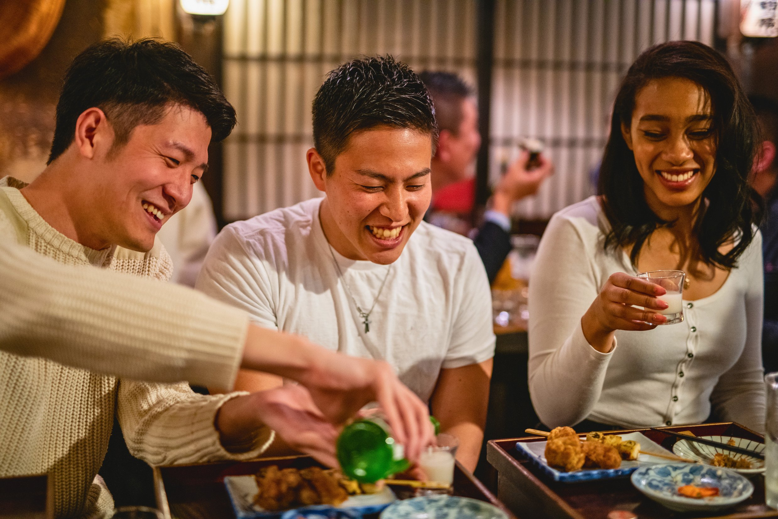 Three Coworkers Having Fun At An Izakaya